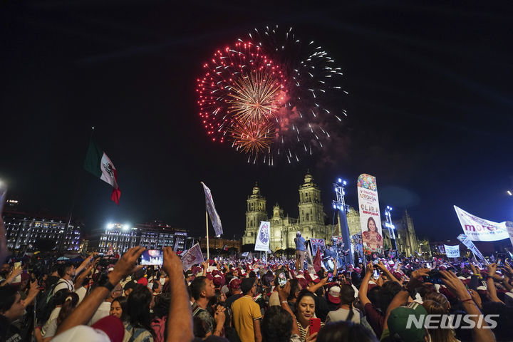 [멕시코시티=AP/뉴시스] 3일(현지시각) 멕시코 소칼로 광장에서 클라우디아 셰인바움 대선 후보 지지자들이 그의 대통령 당선을 축하하는 동안 축하 불꽃이 하늘을 수놓고 있다. 셰인바움 대통령 당선인은 올해 말 누가 미국 대통령이 되더라도 지금까지 그래왔듯이 좋은 관계를 유지할 것이라고 밝혔다. 2024.06.04.