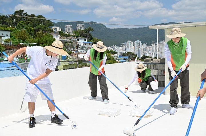 [서울=뉴시스] 한국주택금융공사 직원들과 대학생 봉사단이 4일 부산 금정구 부곡4동에서 주택 옥상에 열차단 페인트를 칠하는 쿨루프 사회공헌활동을 진행하고 있다. (사진=주택금융공사) photo@newsis.com *재판매 및 DB 금지