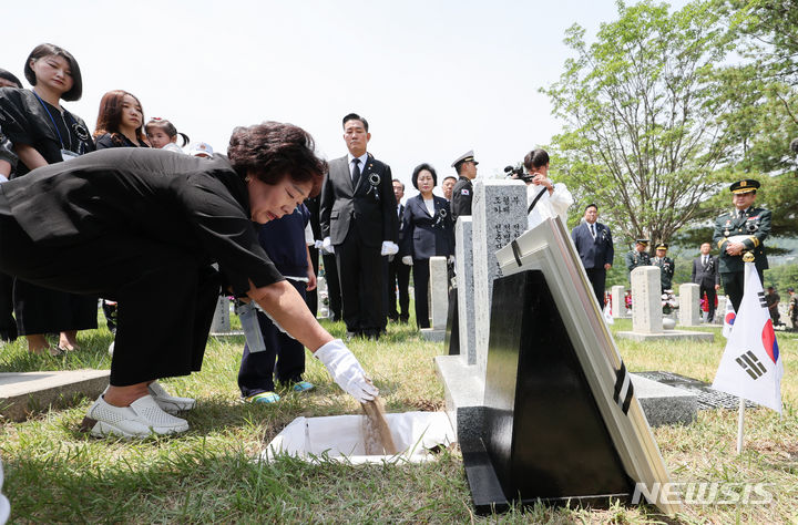 [서울=뉴시스] 황준선 기자 = 5일 오전 서울 동작구 국립서울현충원에서 열린 호국의 형제 안장식에서 유가족이 故 전병섭 하사의 유해에 허토하고 있다. 2024.06.05. hwang@newsis.com