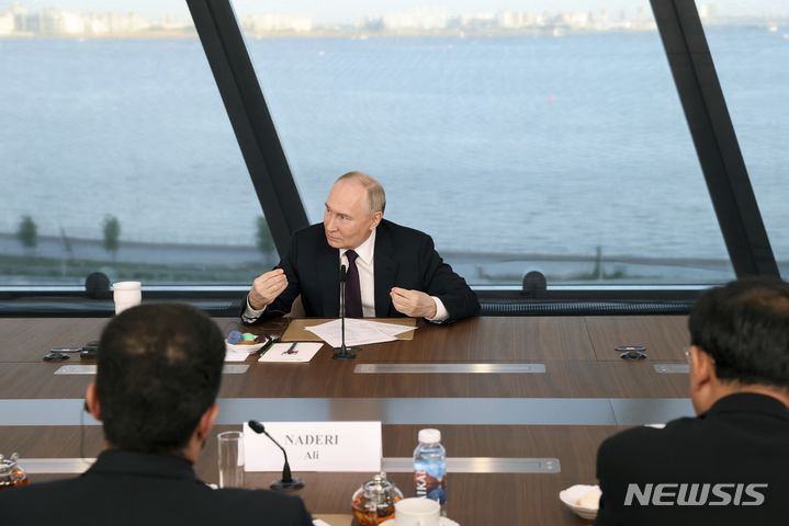 [상트페테르부르크=AP/뉴시스] 블라디미르 푸틴 러시아 대통령이 5일(현지시각) 러시아 상트페테르부르크에 위치한 상트페테르부르크 국제경제포럼(SPIEF) 부스에서 국제 통신사 간부들과 간담회 하고 있다. 2024.06.06.