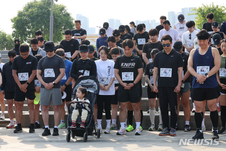 [서울=뉴시스] 김근수 기자 = 서울 지역 경찰관들로 구성된 경찰관 러닝크루 'KNPR'회원들이 6일 서울 서초구 반포한강시민공원 예빛섬 광장에서 러닝에 앞서 묵념을 하고 있다.  서울 지역 경찰관들로 구성된 경찰관 러닝크루 'KNPR'(Korea National Police Runners)와 서울 혜화·동작·서초·방배경찰서는 순직 경찰관 자녀와 가족을 돕는 기부 러닝 행사에서 경찰관과 일반 시민 러너 약 120명이 모여 서울 서초구 예빛섬에서 출발해 동작구 국립서울현충원 일대 6.6.㎞를 달리는 방식으로 진행된다고 밝혔다. 2024.06.06. ks@newsis.com