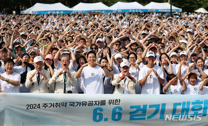 [서울=뉴시스] 홍효식 기자 = 현충일인 6일 서울 중구 남산공원 백범광장에서 열린 2024 주거취약 국가유공자를 위한 6.6 걷기 대회에서 오세훈 서울시장과 6.25 참전용사를 비롯한 시민들이 기념촬영하고 있다. 2024.06.06. yesphoto@newsis.com