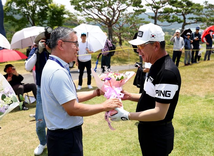 [서울=뉴시스] 김원섭 한국프로골프협회(KPGA) 회장(왼쪽)이 최상호(오른쪽)에게 꽃다발을 전달하고 있다. 2024.06.07. (사진=KPGA 제공) *재판매 및 DB 금지