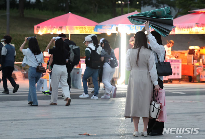 [서울=뉴시스] 이영환 기자 = 지난 7일 오후 서울 영등포구 여의도한강공원에서 시민들이 비가 내리자 비를 피해 이동하고 있다. 2024.06.07. 20hwan@newsis.com