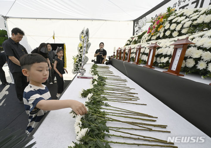 [광주=뉴시스] 박기웅 기자 = 광주 동구 학동 재개발 4구역 철거 붕괴 참사 3주기를 맞은 9일 오후 광주 동구청사 앞에서 추모식이 열렸다. 추모객들이 참사 희생자들에게 헌화하고 있다. 2024.06.09. pboxer@newsis.com