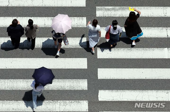 [부산=뉴시스] 하경민 기자 = 무더운 날씨가 이어진 11일 부산 연제구의 한 도로에서 시민들이 뙤약볕을 피하기 위해 양산을 쓴 채 횡단보도를 건너고 있다. 2024.06.11. yulnetphoto@newsis.com