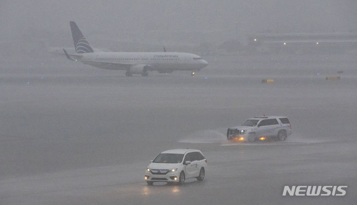 [플로리다=AP/뉴시스] 폭우가 내린 12일(현지시각) 미국 플로리다주 포트로더데일-할리우드 국제공항에서 비행기가 이동하고 있다. 2024.06.13.