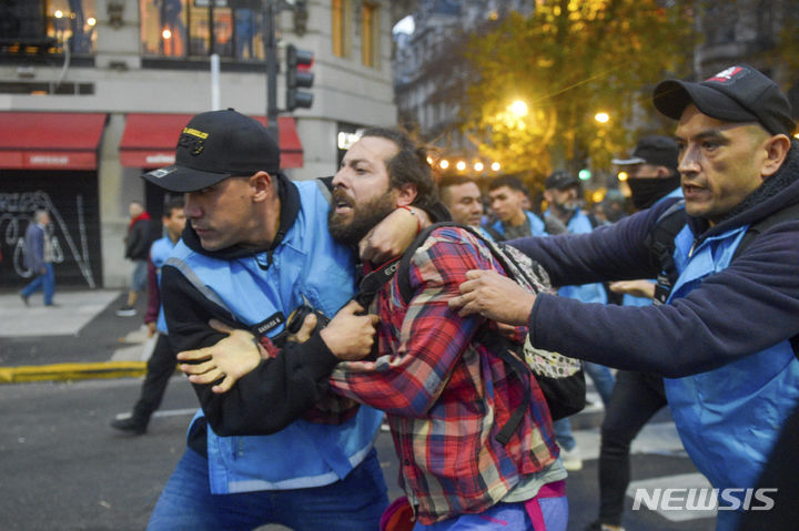 [부에노스아이레스=AP/뉴시스] 12일(현지시각) 아르헨티나 부에노스아이레스 의회에서 국회의원들이 하비에르 마일리 대통령의 개혁안을 논의하는 동안 국회 밖에서 시위하던 한 남성이 경찰에 체포되고 있다. 2024.06.13.
