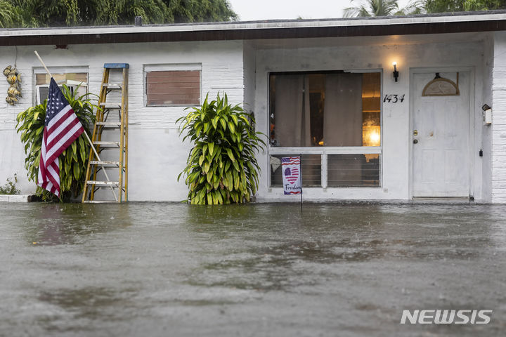 [플로리다=AP/뉴시스] 12일(현지시각) 미국 플로리다주 할리우드에 폭우가 쏟아져 한 주택의 마당이 침수돼 있다. 2024.06.13.