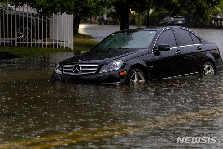 [플로리다=AP/뉴시스] 폭우가 내린 12일(현지시각) 미국 플로리다주 써니 아일랜드 비치에 차량이 침수돼 있다. 2024.06.13.