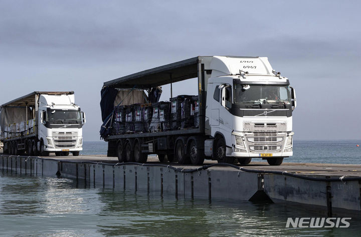 [가자지구=AP/뉴시스]미국이 설치한 가자 지구 임시 부두를 통해 인도주의 지원품이 전달되는 모습. 지난달 풍랑으로 파손됐던 이 부두가 다시 파손되는 것을 막기 위해 미국이 14일(현지시각) 부두를 해안에서 분리했다. 이에 따라 가자 지구에 대한 인도지원품 전달이 1주일 가량 중단될 전망이다. 2024.6.15.