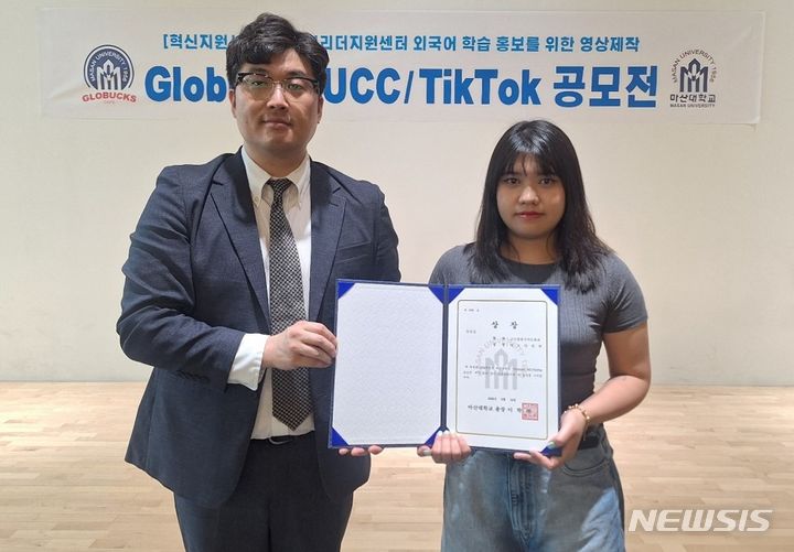 [창원=뉴시스]14일 오후 마산대학교 교내 창의관 1층 특설무대에서 열린 'Globucks UCC & TikTok 공모전' 시상식에서 우수상을 받은 글로벌한국어문화과 까오티빛쩐(오른쪽) 학생이 조현준 글로벌리더지원센터장과 기념촬영하고 있다.(사진=마산대학교 제공) 2024.06.14.  photo@newsis.com