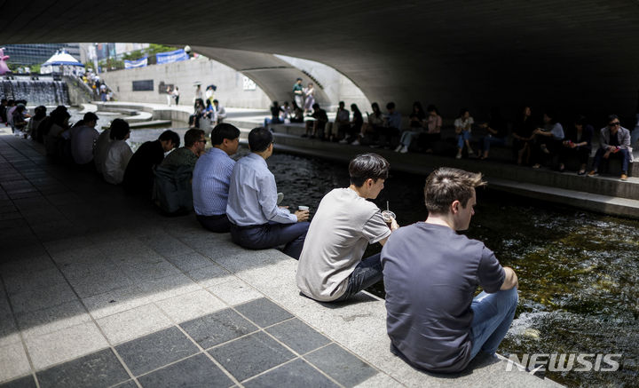 [서울=뉴시스] 정병혁 기자 = 낮 최고기온이 35도로 더운 날씨를 보인 14일 서울 중구 청계천을 찾은 시민들이 그늘에서 더위를 식히고 있다. 2024.06.14. jhope@newsis.com