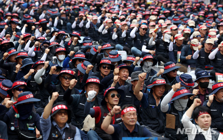 [서울=뉴시스] 추상철 기자 = 15일 오후 서울 영등포구 여의도공원 앞에서 열린 민주노총 공공운수노조 화물연대본부의 '화물노동자 총력투쟁 결의대회'에서 노조원들이 구호를 외치고 있다. 2024.06.15. scchoo@newsis.com