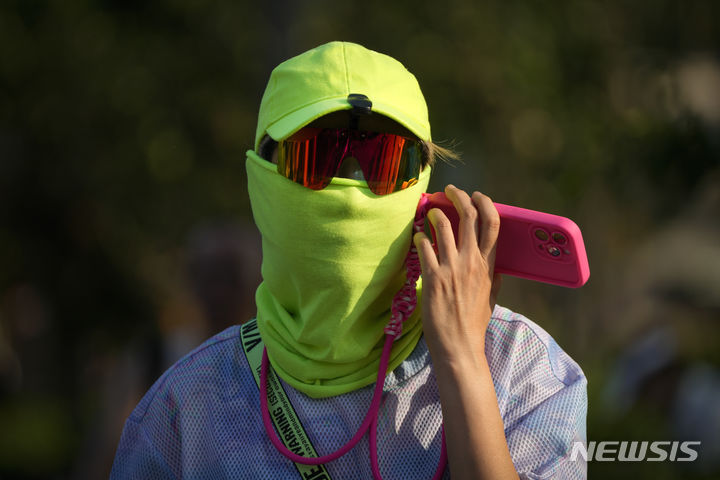 [베이징=AP/뉴시스] 더운 날씨를 보인 16일 중국 베이징에서 한 남성이 자외선 차단용 마스크를 쓴 채 이동하고 있다. 2024.06.17.