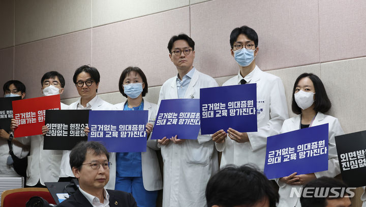 [서울=뉴시스] 김금보 기자 = 서울대병원 교수들이 전공의 사태 해결 등을 요구하며 무기한 휴진에 들어간 17일 오전 서울 종로구 서울대학교 의과대학 융합관 양윤선홀에서 열린 서울대학교 의과대학-서울대학교병원 비상대책위원회 집회에서 교수, 전공의, 의대생들이 손피켓을 들고 있다. 2024.06.17. kgb@newsis.com