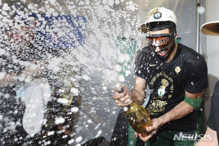 [보스턴=AP/뉴시스] 보스턴 셀틱스의 포워드 제이슨 테이텀이 지난달 17일(현지시각) 미 매사추세츠주 보스턴의 TD 가든에서 열린 20223-24 미국 프로농구(NBA) 파이널 5차전에서 댈러스 매버릭스를 꺾고 우승한 후 샴페인을 터트리고 있다. 보스턴이 106-88로 이기고 시리즈 4승 1패로 우승하며 역대 최다인 18회 우승을 차지했다. 2024.06.18.