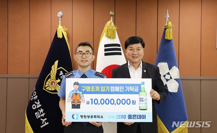 [창원=뉴시스]18일 창원해양경찰서를 방문한 최재호(오른쪽) 창원상공회의소 겸 ㈜무학 회장이 '구명조끼 입기 캠페인'에 동참해 구명조끼 구입용 1000만 원 기탁증서를 전달하고 있다.(사진=창원상의 제공) 2024.06.18. photo@newsis.com