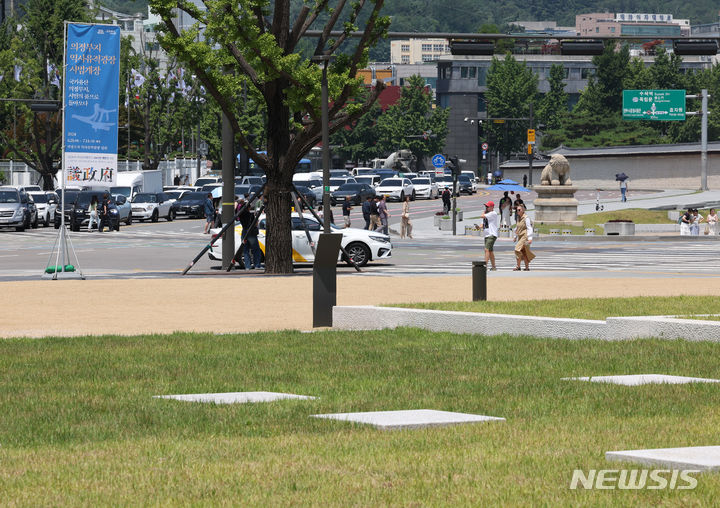 [서울=뉴시스] 배훈식 기자 = 의정부지 역사유적광장이 시범개장한 18일 오전 서울 종로구 광화문삼거리 의정부 터 앞을 관광객들이 지나가고 있다. 2024.06.18. dahora83@newsis.com