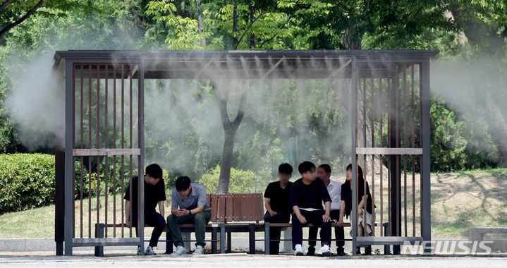 [서울=뉴시스] 김진아 기자 = 서울 지역의 낮 최고기온이 31도까지 오른 18일 서울 영등포구 여의도공원에서 시민들이 쿨링포그 아래서 더위를 피하고 있다. 2024.06.18. bluesoda@newsis.com