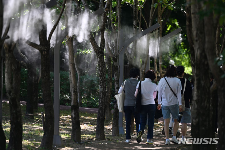 [광주=뉴시스] 이영주 기자 = 광주와 전남 일부 지역에 폭염주의보가 내려진 18일 오후 광주 서구 5·18기념공원에서 시민들이 쿨링포그 아래로 산책하고 있다. 2024.06.18. leeyj2578@newsis.com