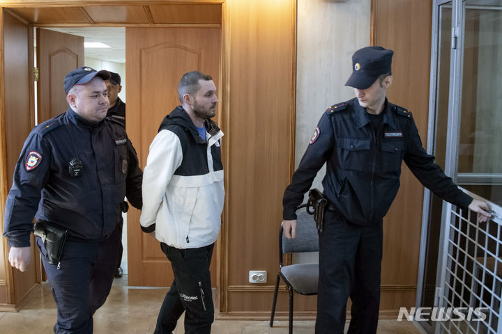 [AP/뉴시스] 미군 하사 고든 블랙이 19일 러시아 블라디보스토크 법원에 호송되어 피고인 격리의 유리 철창 안으로 인도되고 있다. 블랙은 3년9개월 형을 받았다 