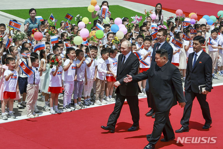 [평양=AP/뉴시스] 블라디미르 푸틴(왼쪽) 러시아 대통령이 19일 김정은 북한 국무위원장과 함께 북한 평양의 김일성 광장에서 열리는 공식 환영식장에 도착해 환영나온 어린이들 앞을 지나고 있다. 2024.06.19.