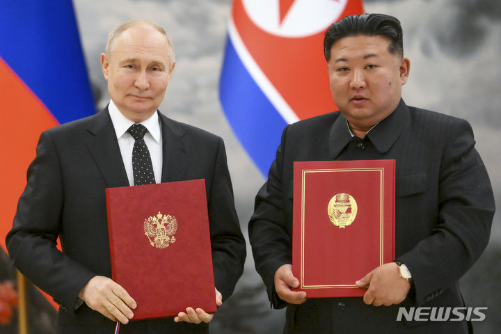 [평양=AP/뉴시스] 블라디미르 푸틴(왼쪽) 러시아 대통령과 김정은 북한 국무위원장이 19일 북한 평양 금수산 영빈관에서 '포괄적 전략 동반자 협정'을 체결한 후 협정서를 들고 기념 촬영하고 있다. 이번 협정에는 어느 한 나라가 공격을 받으면 상호 지원을 제공하는 '유사시 상호 지원' 조항도 포함됐다. 협정체결에 따라 한반도에서 긴장이 고조될 가능성이 우려된다. 2024.06.20.