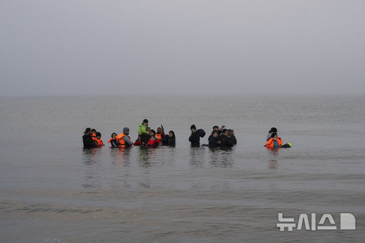 [암블레테우스 해변(프랑스)=AP/뉴시스]지난 해 5월19일 프랑스 북부 암블레테우스 해변에서 프랑스 경찰에 적발돼 도버 해협을 건널 보트 탑승에 실패한 이란과 이라크 출신 쿠르드인들에 프랑스 해안으로 돌아오기를 거부한 채 바닷물 속에 남아 있다. 영국과 이라크는 불법 이민의 영국 상륙을 막기 위한 협정에 서명했다고 영국정부가 8월 20일 발표했다. 2025.08.21.