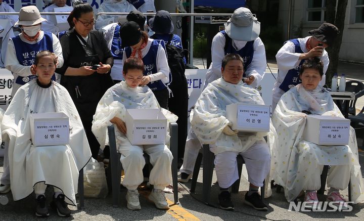 [청주=뉴시스] 서주영 기자 = 19일 오전 충북장애인부모연대 관계자가 충북 도청 정문 앞에서 정부에 발달장애인 가족을 위한 정책 마련을 촉구하며 삭발을 하고 있다. 2024.06.19. juyeong@newsis.com *재판매 및 DB 금지