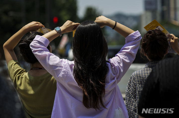 [서울=뉴시스] 정병혁 기자 = 서울을 비롯한 대부분의 지역에 폭염주의보가 발령된 19일 서울 종로구 광화문네거리에서 햇빛을 가린 시민들이 이동하고 있다. 2024.06.19. jhope@newsis.com