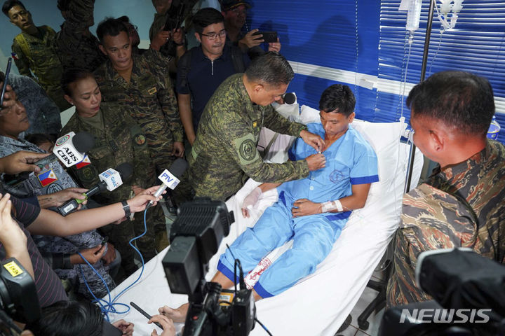 [팔라완(필리핀)=AP/뉴시스] 19일(현지시각) 로미오 브라우너 필리핀 군 참모총장은 팔라완의 한 병원에서 중국 해경과의 충돌에서 부상을 입은 해군 요원에게 훈장을 수여하고 있다. 2024.06.20 