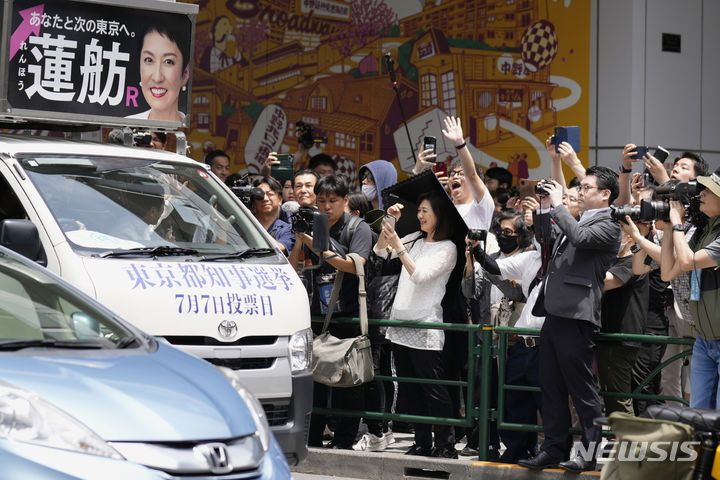 [도쿄=AP/뉴시스]20일 도쿄에서 도쿄 도지사 선거를 위한 선거 활동이 공식적으로 허용됨에 따라 도쿄도지사 선거 후보 지지자들과 구경꾼 등이 후보자 사진과 영상을 찍고 있다. 2024.06.26.