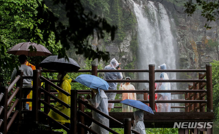 [서귀포=뉴시스] 우장호 기자 = 서귀포시 강정동에 위치한 엉또폭포를 찾은 관광객들이 시원스럽게 떨어지는 물줄기를 감상하고 있다. (사진=뉴시스DB) woo1223@newsis.com