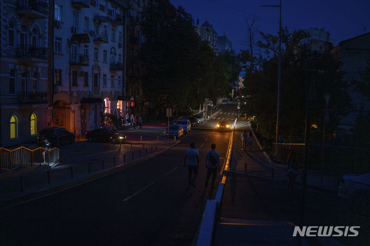 [키이우=AP/뉴시스]6일(현지시각) 우크라이나 수도 키이우 중심부에서 정전이 발생한 동안 사람들이 도로를 걷고 있다. 2024.06.22.