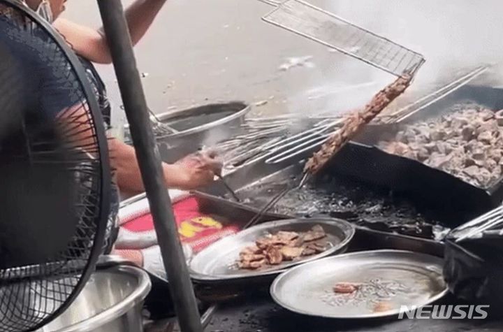 베트남 하노이의 한 노점상에서 숯이 섞인 검은 물에 고기를 담갔다 굽는 충격적인 영상이 공개됐다. 출처 : @HỒNG QUANG *재판매 및 DB 금지