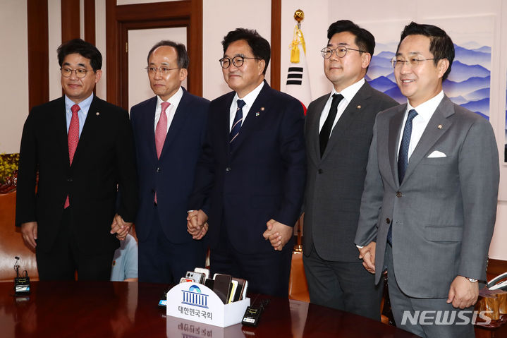 [서울=뉴시스] 고승민 기자 = 우원식 국회의장과 여야 원내대표가 21일 오후 서울 여의도 국회 의장실에서 가진 원 구성 관련 회동에서 손을 맞잡고 기념촬영을 하고 있다.    왼쪽부터 국민의힘 배준영 원내수석부대표, 추경호 원내대표, 우 의장, 더불어민주당 박찬대 원내대표, 박성준 원내수석부대표. (공동취재) 2024.06.21. photo@newsis.com