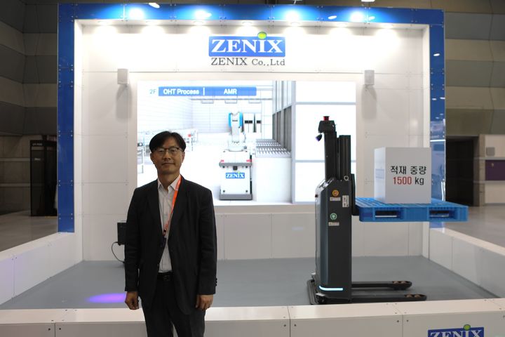 배성관 제닉스 대표이사가 대표 제품 AGV 앞에서 포즈를 취하고 있다. (사진=제닉스) *재판매 및 DB 금지