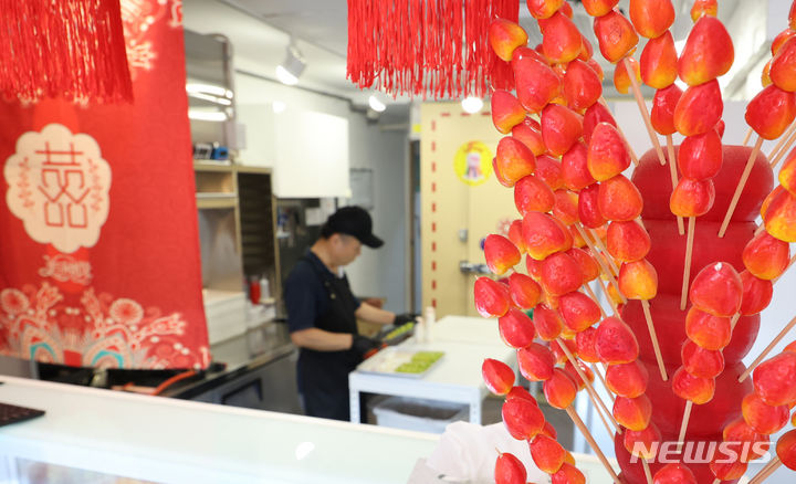 [서울=뉴시스] 김금보 기자 = 24일 서울시내 한 탕후루 가게에서 업주가 영업준비를 하고 있다. 탕후루 열풍이 시들면서 우후죽순 생겨났던 탕후루 가게들이 줄지어 폐업 하고 있다. 2024.06.24. kgb@newsis.com