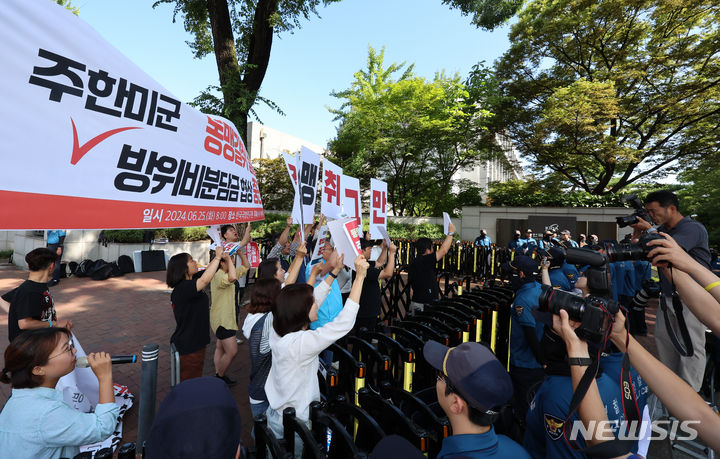 [서울=뉴시스] 김근수 기자 = 겨레하나와 서울자주통일평화연대 회원들이 25일 오전 서울 동대문구 한국국방연구원에서 열린 제12차 한·미 방위비분담특별협정(SMA) 4차 회의를 반대하는 손 피켓을 들고 미국측 대표단이 탄 버스를 향해 구호를 외치고 있다. 2024.06.25. ks@newsis.com