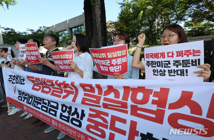 [서울=뉴시스] 김근수 기자 = 겨레하나 회원들이 25일 오전 서울 동대문구 한국국방연구원에서 열린 제12차 한·미 방위비분담특별협정(SMA) 4차 회의를 반대하는 손 피켓을 들고 구호를 외치고 있다. 2024.06.25. ks@newsis.com