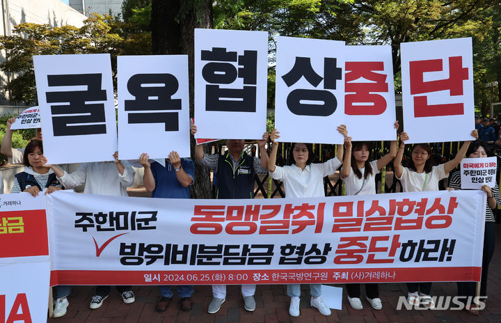 [서울=뉴시스] 김근수 기자 = 겨레하나 회원들이 25일 오전 서울 동대문구 한국국방연구원에서 열린 제12차 한·미 방위비분담특별협정(SMA) 4차 회의를 반대하는 손 피켓을 들고 구호를 외치고 있다. 2024.06.25. ks@newsis.com