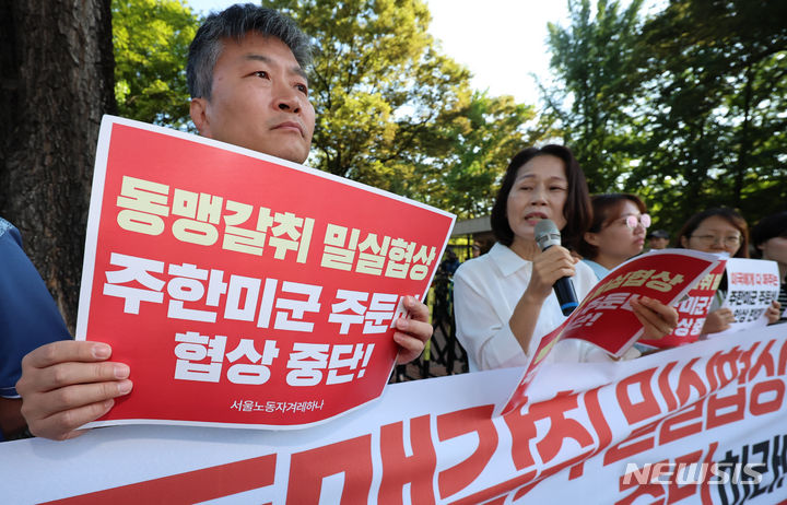 [서울=뉴시스] 김근수 기자 = 겨레하나 회원들이 25일 오전 서울 동대문구 한국국방연구원에서 열린 제12차 한·미 방위비분담특별협정(SMA) 4차 회의를 반대하는 손 피켓을 들고 서 있다. 2024.06.25. ks@newsis.com