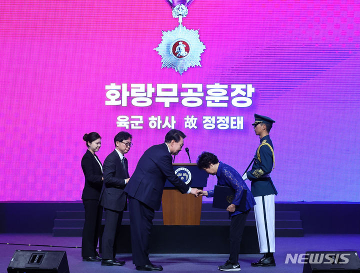 [대구=뉴시스] 최진석 기자 = 윤석열 대통령이 25일 대구 북구 엑스코에서 열린 6·25전쟁 74주년 행사에서 6.25전쟁 당시의 공적이 최근에 확인된 1사단 15연대 소속 고 정정태 하사의 동생 정정순 씨에게 화랑무공훈장을 수여하고 있다. 2024.06.25. myjs@newsis.com