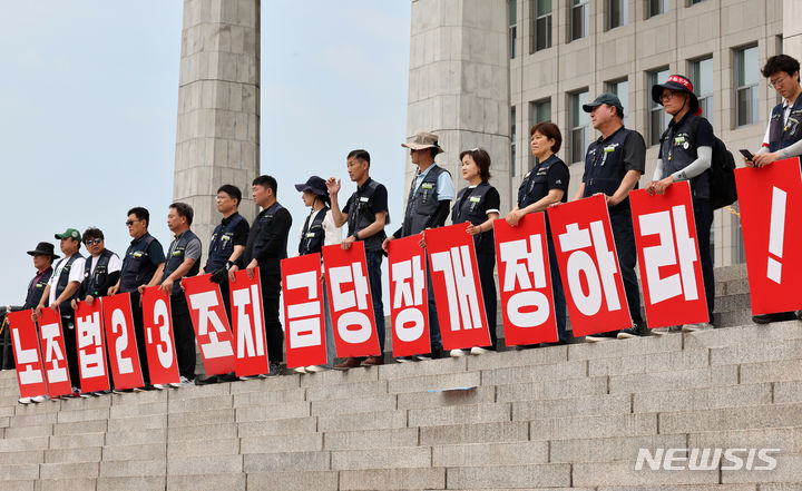 [서울=뉴시스] 조성우 기자 = 민주노총 조합원들이 25일 오전 서울 여의도 국회 본관 앞 계단에서 노조법 2·3조 개정안 통과를 촉구하는 피켓을 들고 있다. 2024.06.25. xconfind@newsis.com