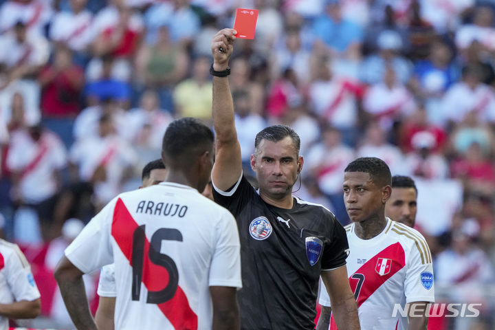 [캔자스시티=AP/뉴시스] 26일(한국시각) 미국 캔자스주 캔자스시티의 칠드런스 머시 파크에서 열린 '2024 남미축구연맹(CONMEBOL) 코파아메리카' 조별리그 A조 2차전 캐나다와 페루의 경기에서 주심이 페루의 미겔 아라우호(포틀랜드)에게 퇴장을 선언하고 있다. 2024.06.26.