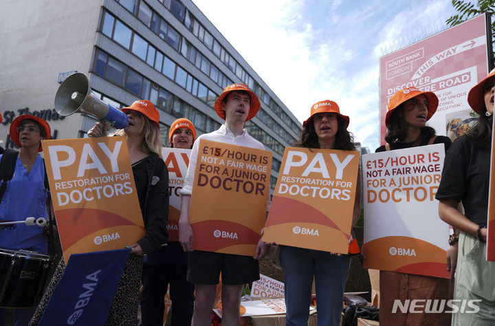 [런던=AP/뉴시스] 27일(현지시각) 영국 런던의 세인트토머스 병원 밖에서  수련의들이 피켓을 들고 임금 인상 시위에 참여하고 있다. 2024.06.27
