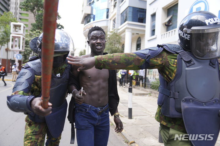 [나이로비(케냐)=AP/뉴시스]케냐 전투경찰들이 지난 25일 케냐 수도 나이로비에서 세금 인상 반대 시위를 벌이던 한 청년을 체포하고 있다. 케냐 고등법원이 28일 며칠 동안 세금 인상에 반대하는 시위가 경찰을 압도함에 따라 질서 회복을 위한 군사력 사용을 승인했다고 BBC가 보도했다.