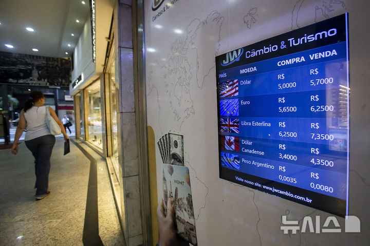 [리우데자네이루=AP/뉴시스] 브라질 최대도시 리우데자네이루 시내에 설치한 달러 등 주요국 통화 환율을 보여주는 전광판 앞을 한 보행자가 지나가고 있다. 2024.08. 20. 
