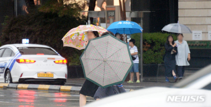 [전주=뉴시스] 김얼 기자 = 전북 전주시 덕진구 백제대로에서 시민들이 우산으로 비를 피하며 길을 지나고 있다. 2024.06.29. pmkeul@newsis.com